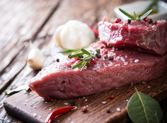 Raw beef steak on wooden table