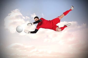Fototapeta na wymiar Composite image of fit goal keeper jumping up