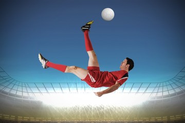 Fototapeta na wymiar Composite image of football player in red kicking