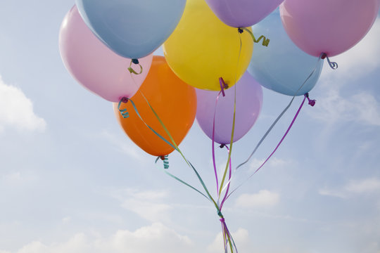 A bunch of balloons floating in the air.
