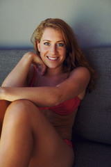 Naklejka premium Attractive woman in bikini sitting on couch