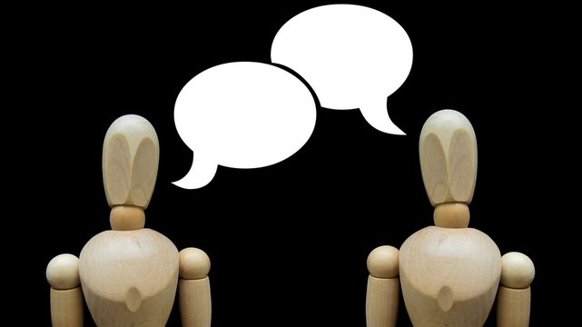Figuras de madera en conversaci&oacute;n.