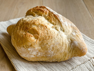 Loaf of white bread on the wooden table