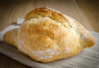 Loaf of white bread on the wooden table
