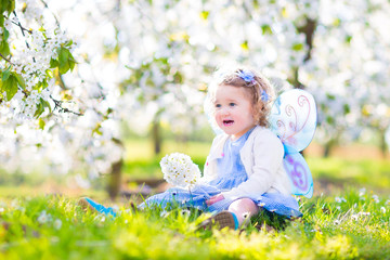 Cute toddler girl in fairy costume in fruit apple garden © famveldman