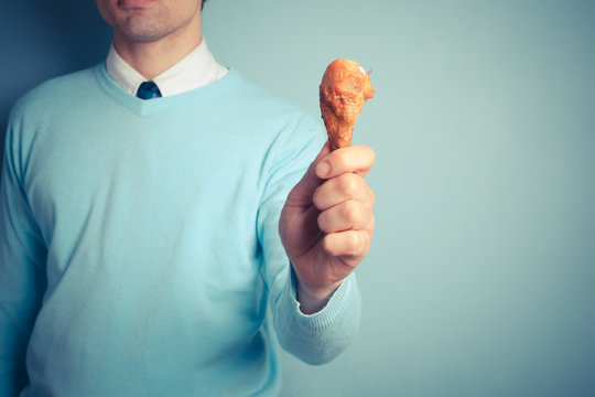 Man holding a chicken drumstick