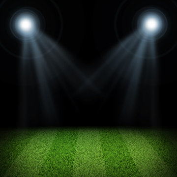 Night football arena illuminated by spotlights