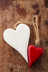 two wooden hearts, red and white on old wooden background © Elena Moiseeva