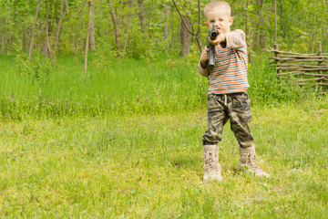 Little boy pointing an automatic weapon