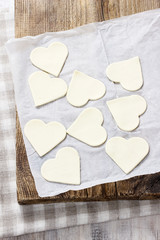 Obraz premium Making puff pastry cookies in heart shape filled with strawberri