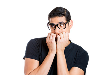 Nerdy anxious guy with glasses biting his fingernails