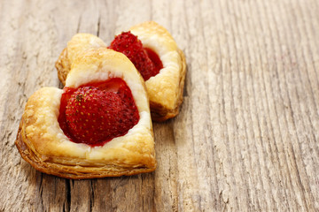 Puff pastry cookies in heart shape filled with strawberries