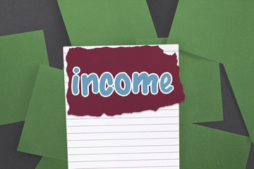 Income against green paper strewn over black