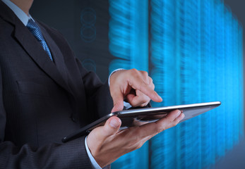 businessman hand using tablet computer and server room backgroun