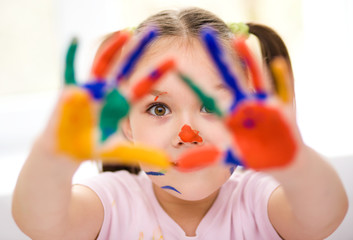 Portrait of a cute girl playing with paints