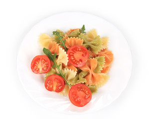 Colored farfalle with tomatoes on white plate.