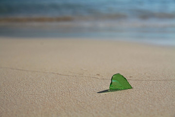 Single Piece of Green Sea Glass on a Sunny Beach