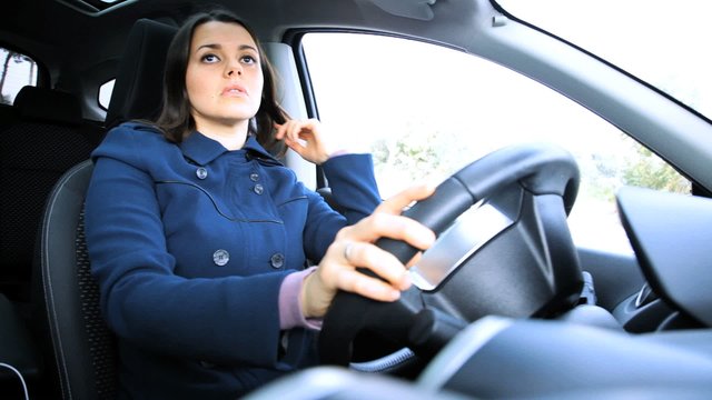Woman putting on seatbelt in car ok sign