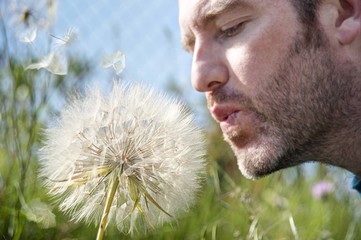 Man blowing a dandelion