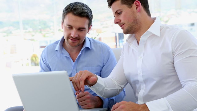 Businessmen working together on laptop