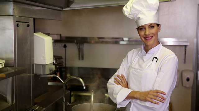 Pretty chef standing beside a large steaming pot