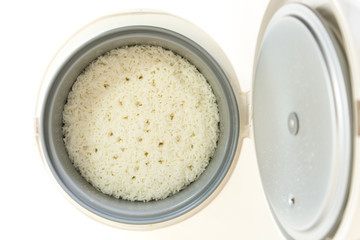 Stream rice in electric rice cooker on white background, isolate