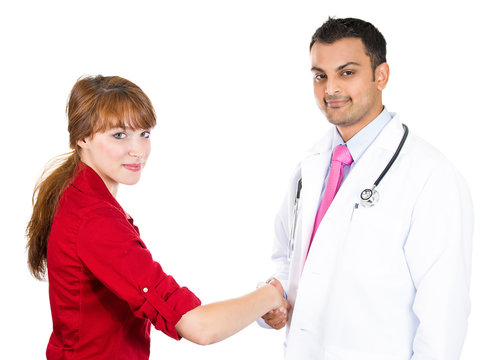 Healthcare professional gives  handshake to female patient 