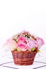 Fototapeta na wymiar pink roses in brown basket of withe background