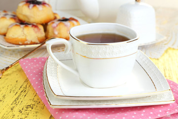 Cup of tea with sweet pastries on table close-up