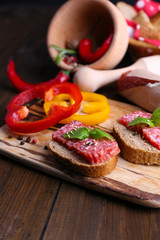 Composition with knife,  tasty sandwiches with salami sausage,