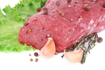 Raw beef meat with lettuce and spices close up