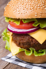 big hamburger with meat, cheese, tomato, onion and lettuce