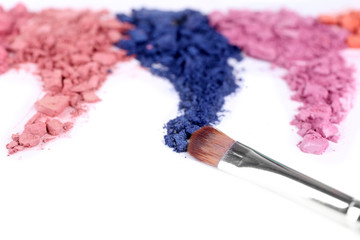 Crushed eyeshadow with brush isolated on white