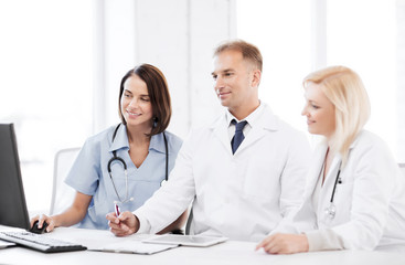 doctors looking at computer on meeting