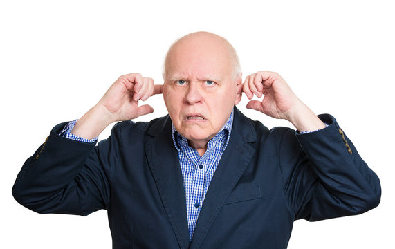 I'm not listening. Senior man plugs his ears, avoiding situation