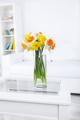 Beautiful spring flowers in vase on home interior background