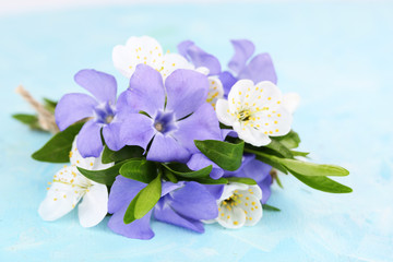 Beautiful bouquet with periwinkle flowers on blue table