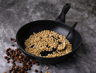 Cedar pine nuts on pan, on wooden table