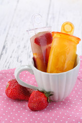 Fruit ice cream in cup on wooden table close-up