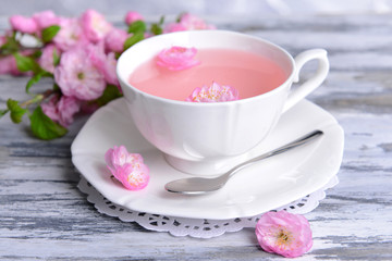 Fototapeta na wymiar Beautiful fruit blossom with cup of tea on table close-up