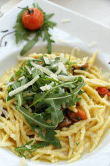 pasta trofie with clams and decorated with rucola and parmesan