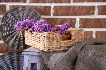Fototapeta na wymiar Beautiful lilac flowers in wicker basket,