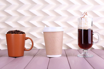 Assortment of coffee drinks on wooden table, on light