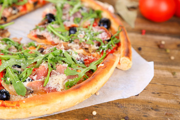 Pizza with arugula on color wooden background