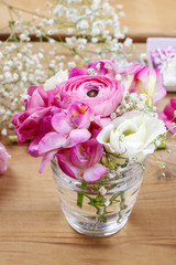 Florist workplace: incomplete tiny bouquets in glass vases. Step