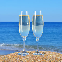 Two Glasses of champagne on a beach sand