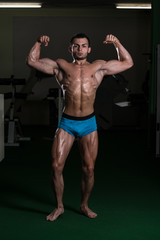 Fototapeta na wymiar Bodybuilder Performing Front Double Biceps Poses