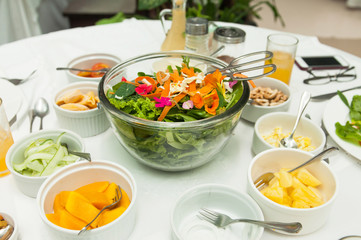 a bowl of salad with a lot of different toppings to mix with