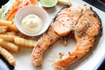 grilled salmon steak with french fries and toast.