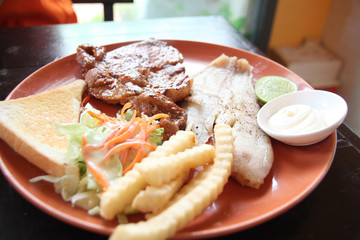 grilled pork steak with french fries and toast.